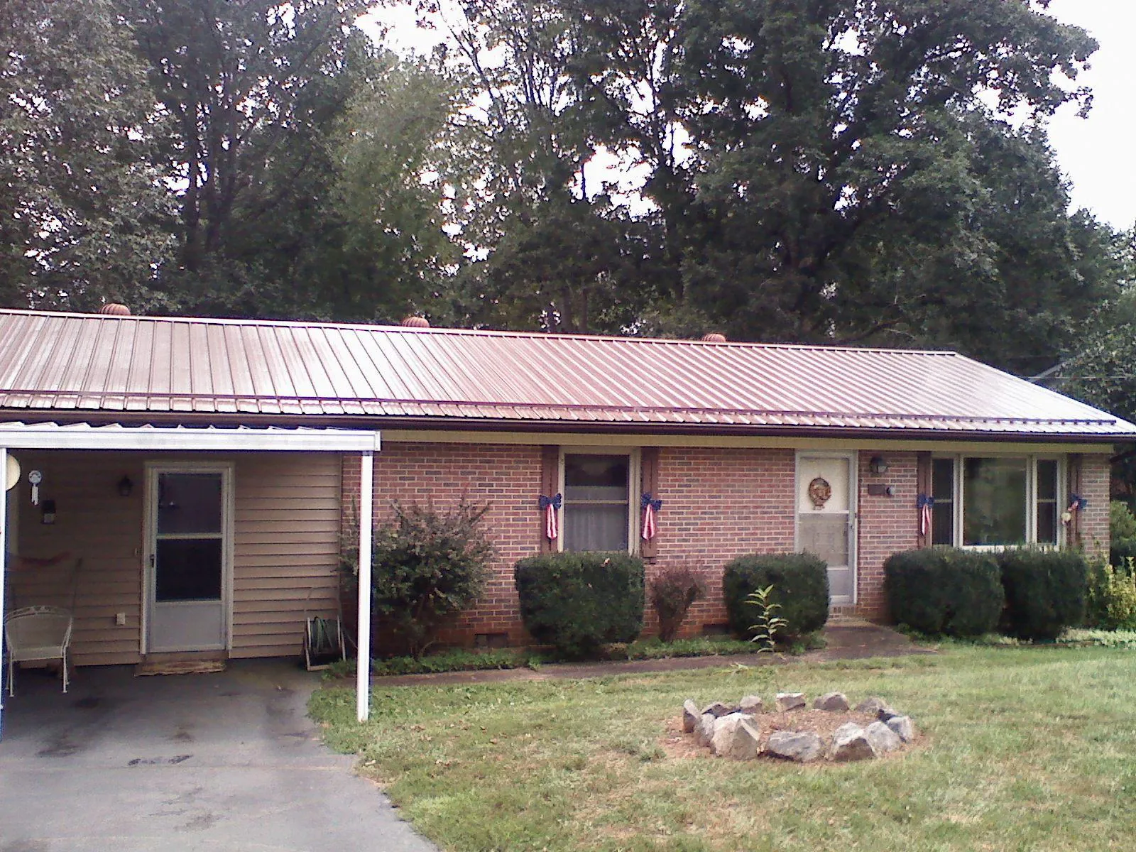 Bronze metal roof and carport on a brick ranch home — Roof Repair work by our crew in Deer Park